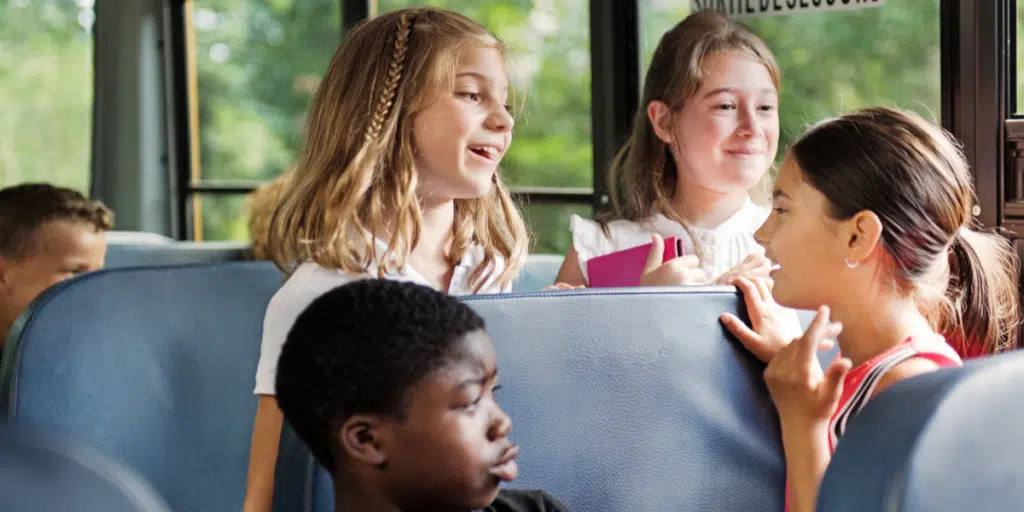 Students on a school bus chatting